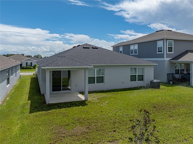 rear view of property with central air condition unit, a yard, and a patio