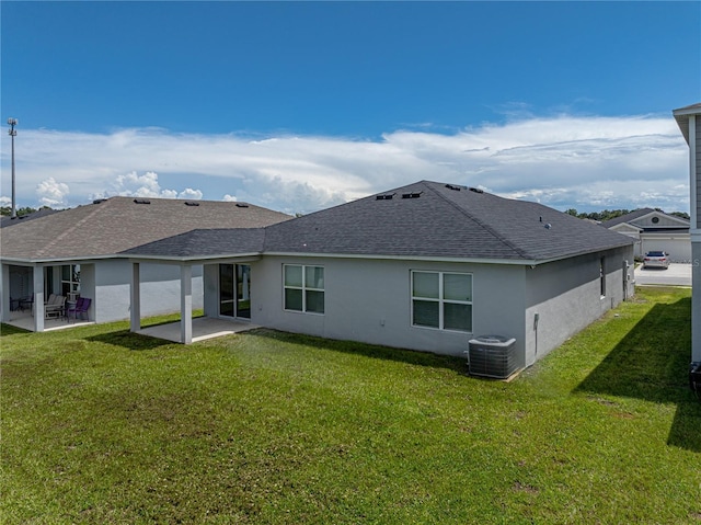 rear view of house with a patio area, central AC, and a yard