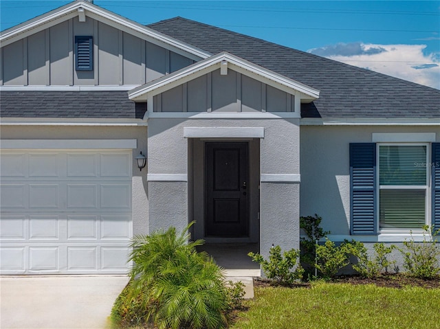 1029 Mattie Pointe Way, Auburndale, FL 33823 - view of exterior entry with stucco siding, a garage, board and batten siding, and roof with shingles