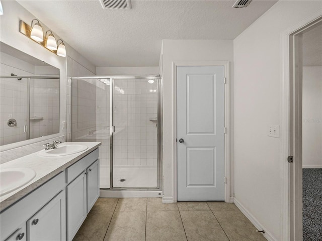 1029 Mattie Pointe Way, Auburndale, FL 33823 - bathroom featuring a stall shower, tile patterned floors, a sink, a textured ceiling, and visible vents