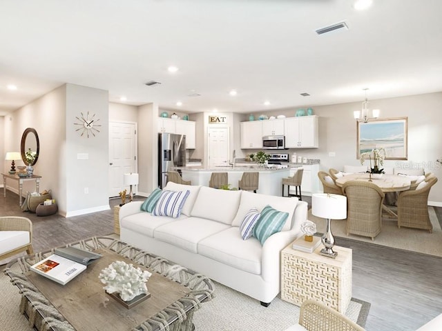 living room with wood-type flooring and a chandelier