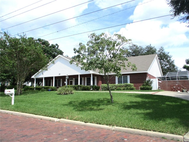 view of front of house featuring a front lawn and brick siding