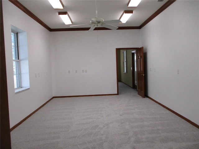 empty room featuring light carpet, ornamental molding, and ceiling fan