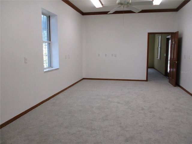 unfurnished room featuring light carpet, crown molding, and baseboards