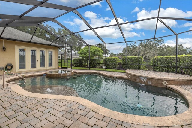 view of swimming pool featuring pool water feature, an in ground hot tub, a lanai, and french doors