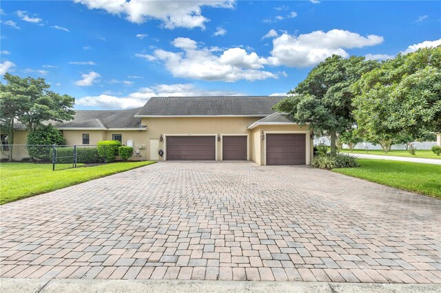 ranch-style house featuring a front yard and a garage