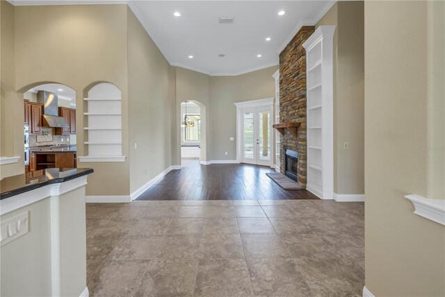 interior space featuring a stone fireplace, light hardwood / wood-style floors, and crown molding