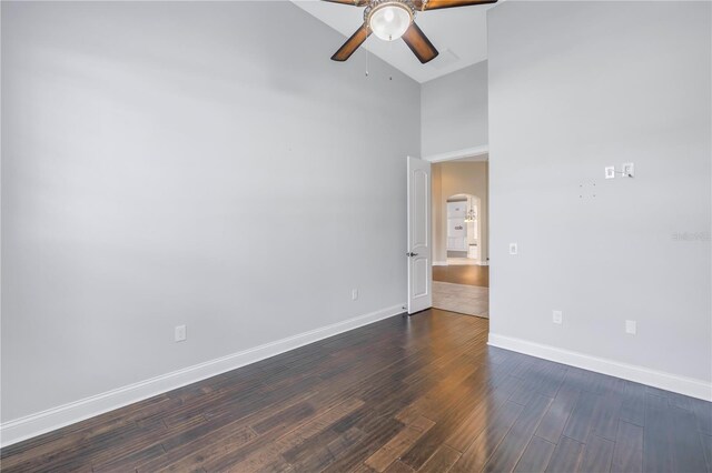 unfurnished room featuring dark hardwood / wood-style floors, ceiling fan, and high vaulted ceiling