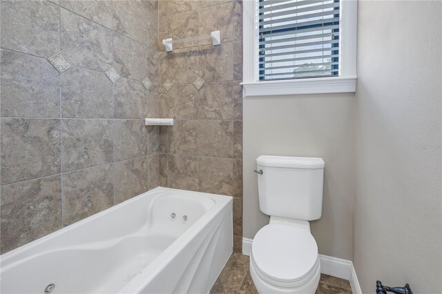 bathroom featuring a washtub and toilet