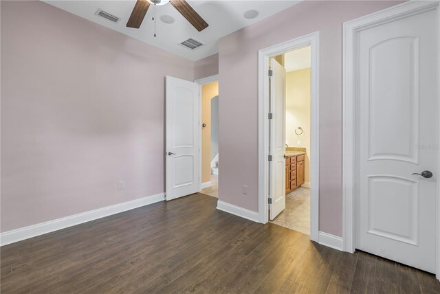 unfurnished bedroom with connected bathroom, ceiling fan, and dark hardwood / wood-style floors