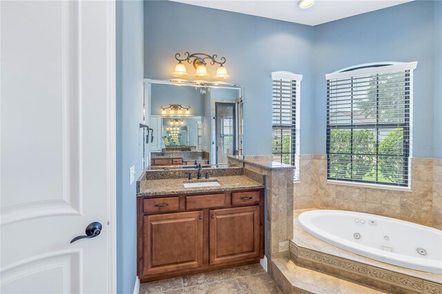 bathroom with tiled tub and vanity