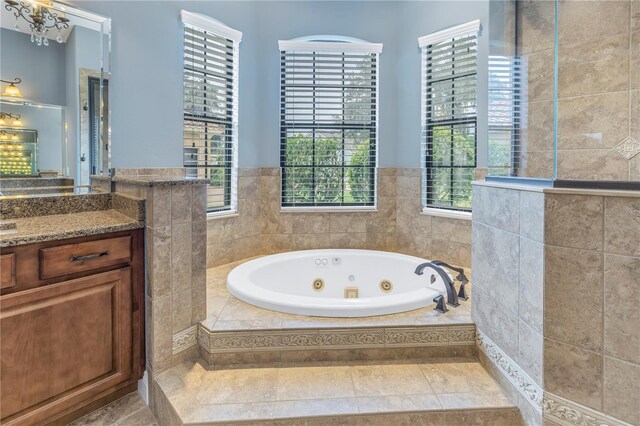 bathroom featuring tiled tub and vanity