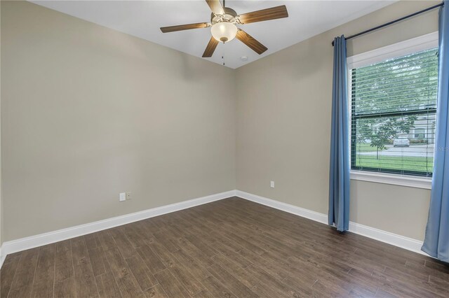 spare room with dark wood-type flooring and ceiling fan