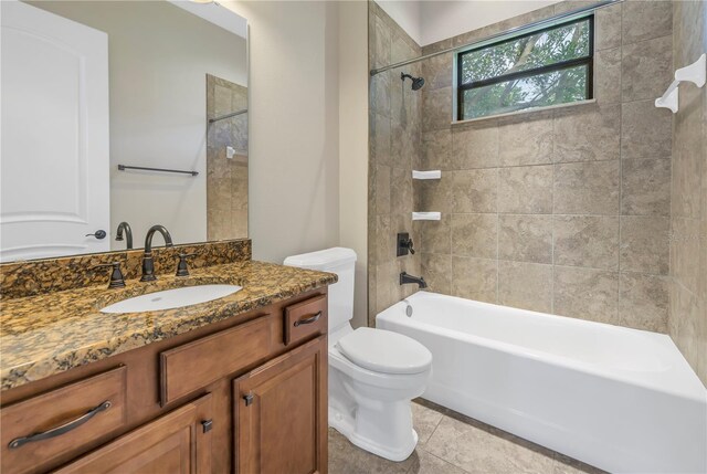 full bathroom featuring tiled shower / bath, vanity, tile patterned flooring, and toilet