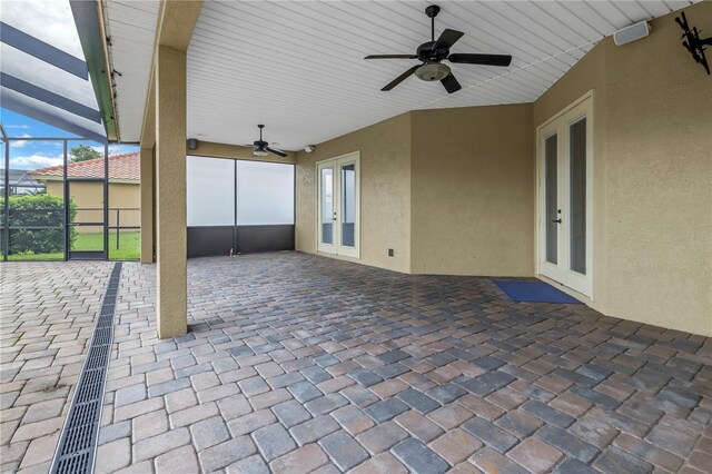 view of patio with glass enclosure, ceiling fan, and french doors