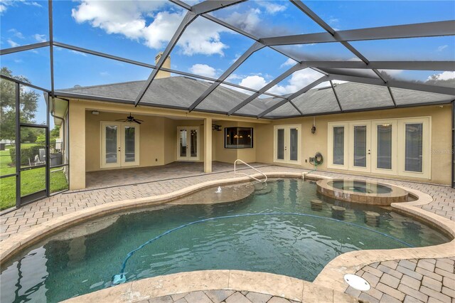 view of swimming pool with a lanai, a patio area, an in ground hot tub, ceiling fan, and french doors