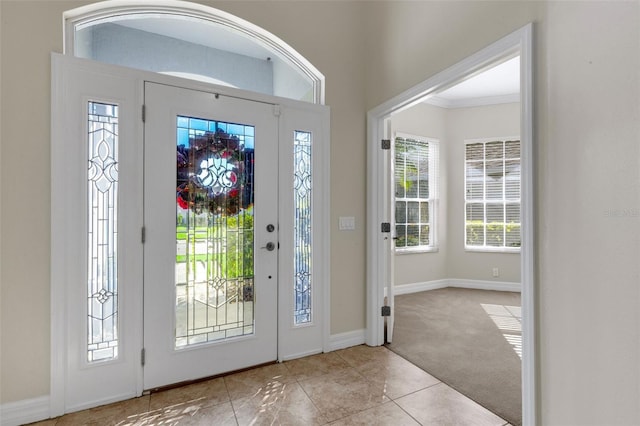 entryway with light colored carpet and crown molding