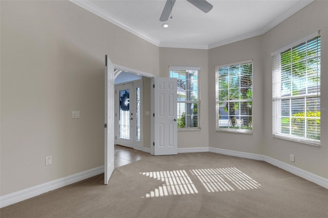 carpeted spare room featuring ceiling fan, plenty of natural light, and crown molding