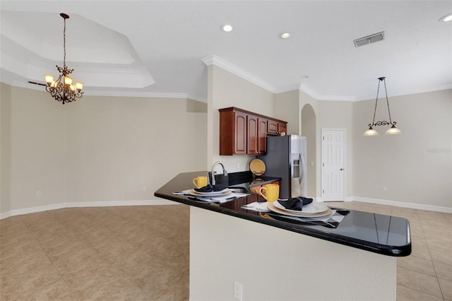 kitchen with hanging light fixtures, kitchen peninsula, crown molding, stainless steel refrigerator with ice dispenser, and a notable chandelier