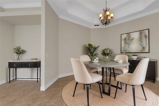 tiled dining area with ornamental molding, a tray ceiling, and a chandelier