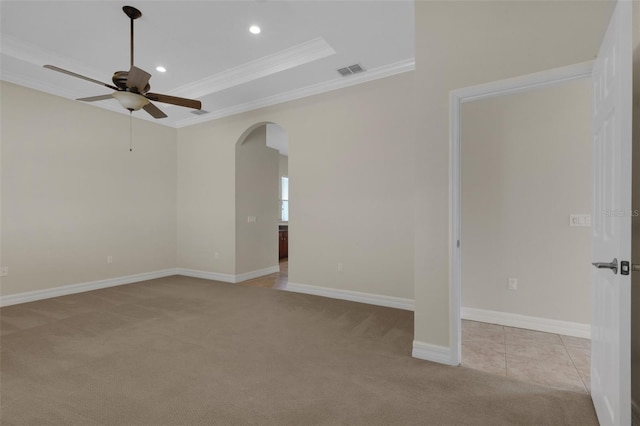 carpeted empty room featuring ceiling fan, a raised ceiling, and crown molding