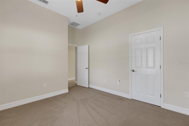 unfurnished bedroom featuring light carpet and ceiling fan