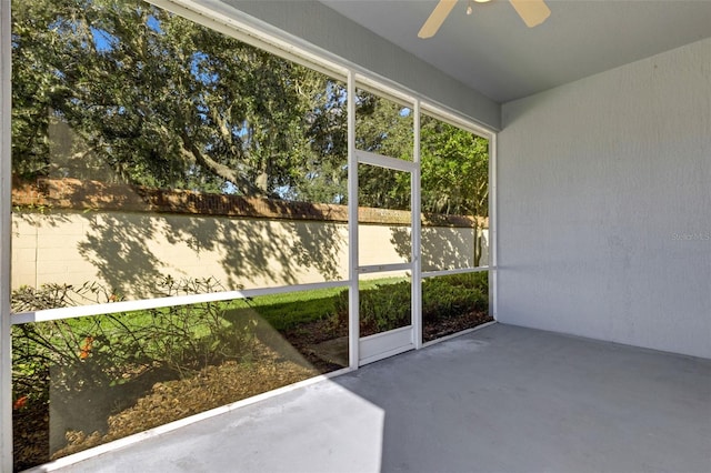 unfurnished sunroom featuring ceiling fan