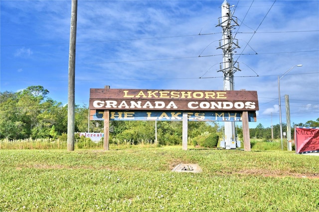 community sign featuring a lawn