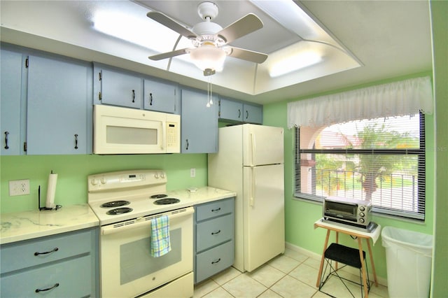 kitchen with light tile patterned floors, white appliances, ceiling fan, and a raised ceiling