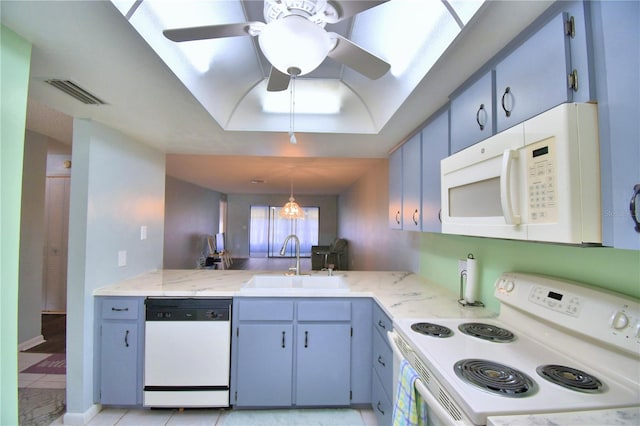 kitchen with hanging light fixtures, white appliances, ceiling fan, a skylight, and sink