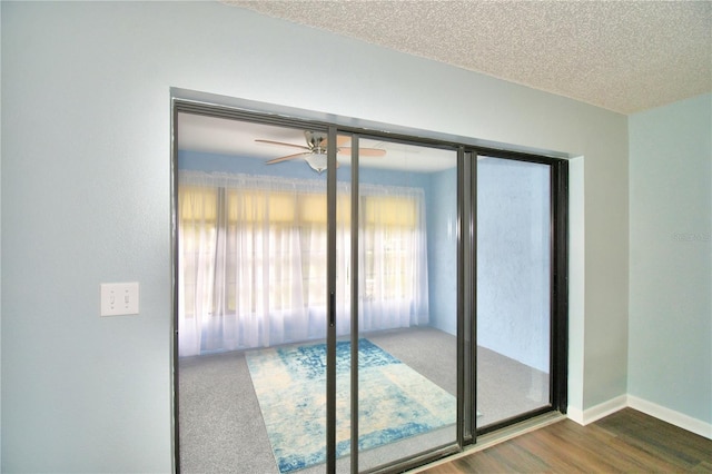 doorway featuring ceiling fan, a textured ceiling, and dark hardwood / wood-style flooring