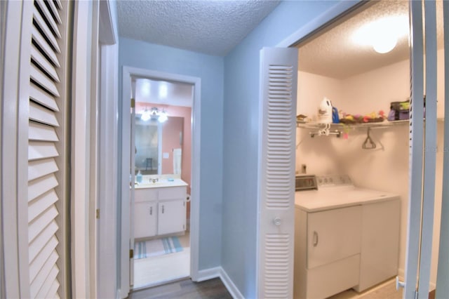 washroom featuring a textured ceiling, sink, and washer and dryer