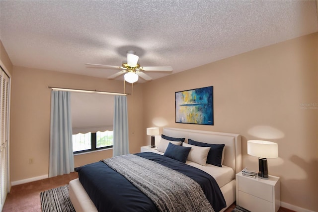 bedroom featuring a closet, ceiling fan, carpet flooring, and a textured ceiling