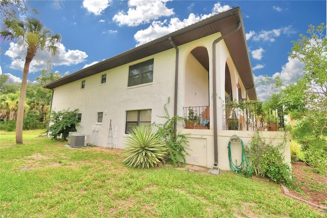 view of side of property with a yard and central air condition unit