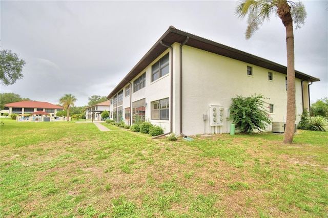 view of home's exterior featuring central AC unit and a lawn