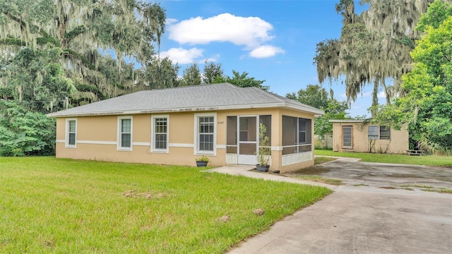 view of front of house featuring a sunroom and a front lawn