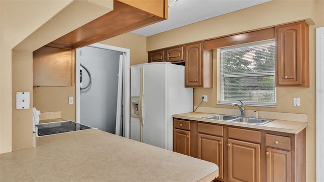 kitchen featuring white fridge with ice dispenser and sink