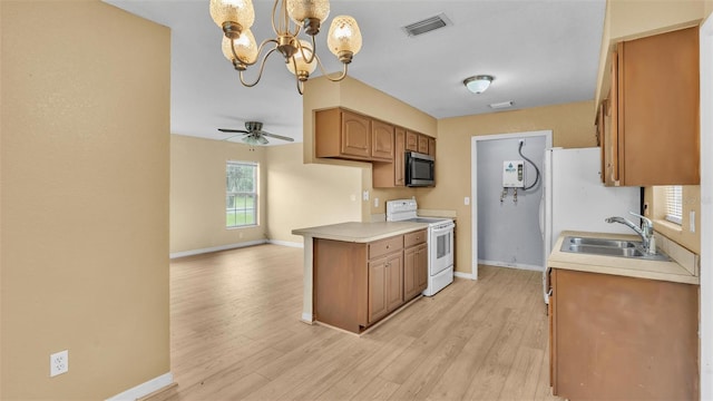 kitchen featuring hanging light fixtures, light wood-type flooring, ceiling fan with notable chandelier, white appliances, and sink