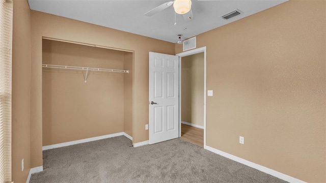 unfurnished bedroom with carpet floors, ceiling fan, and a closet