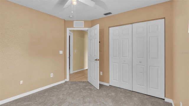 unfurnished bedroom featuring light colored carpet, ceiling fan, and a closet