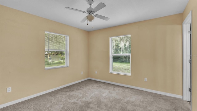 carpeted spare room with ceiling fan