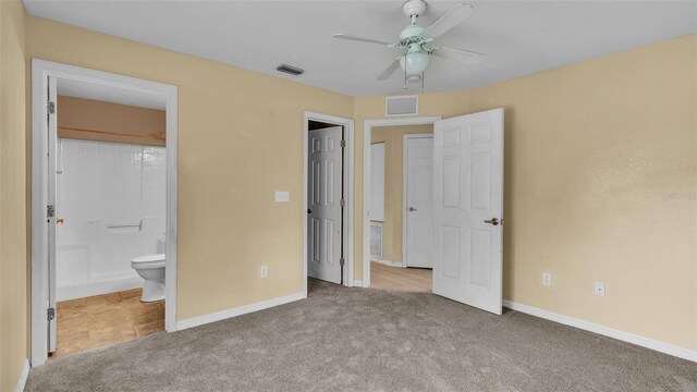 unfurnished bedroom with light colored carpet, ensuite bathroom, and ceiling fan