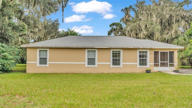 back of house featuring a yard and a sunroom