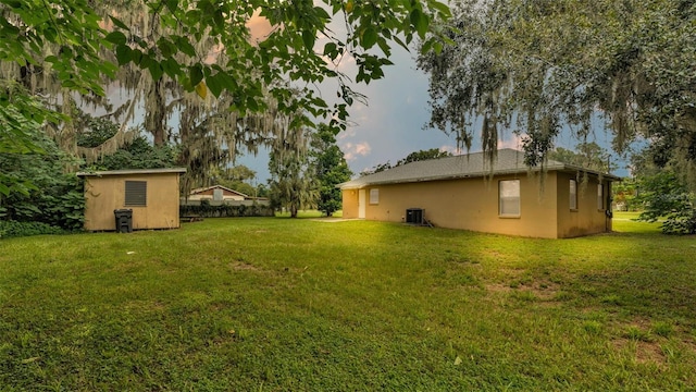 view of yard with central AC and a storage unit