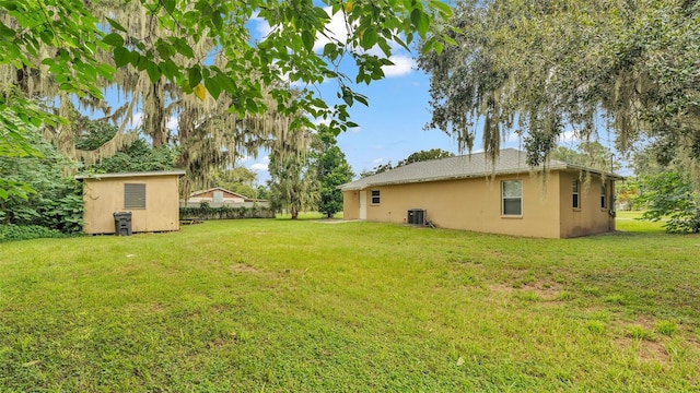 view of yard with central AC and a shed