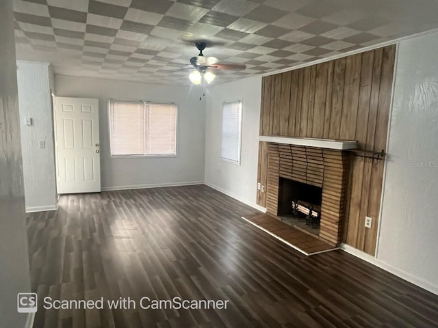 unfurnished living room featuring ceiling fan, dark hardwood / wood-style flooring, and a brick fireplace