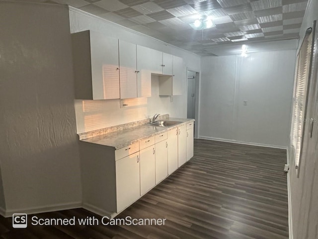 kitchen featuring white cabinetry, dark hardwood / wood-style flooring, backsplash, and sink