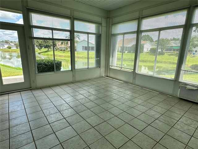 unfurnished sunroom with cooling unit, a water view, and plenty of natural light