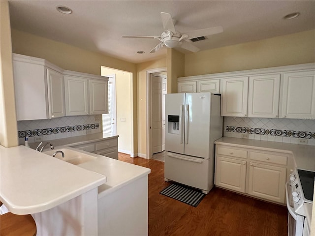 kitchen featuring dark wood-type flooring, white cabinets, white appliances, kitchen peninsula, and ceiling fan