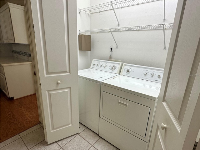 laundry room featuring light tile patterned floors and separate washer and dryer